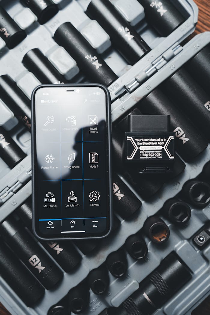 Close-up of a smartphone displaying a diagnostic app with a vehicle diagnostic tool and socket set.